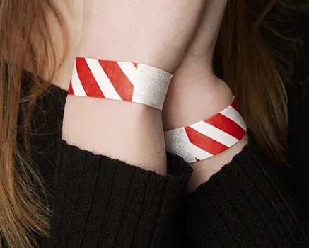 Punainen ja valkoinen raidallinen paperinen ranneke