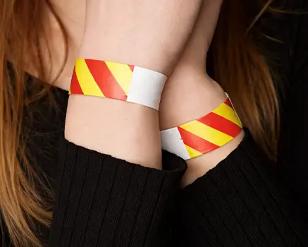 Punainen ja keltainen raidallinen paperinen ranneke